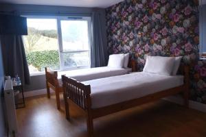 a bedroom with two beds and a window at Lunan House in Arbroath