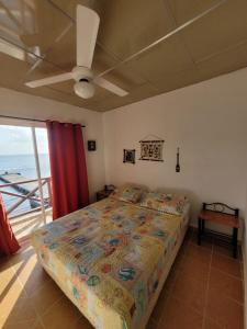 1 dormitorio con 1 cama y vistas al océano en ScubaPortobelo, en Portobelo