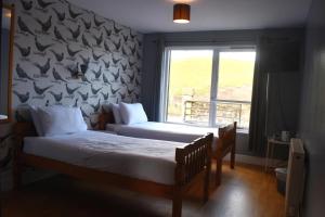 a bedroom with two beds and a window at Lunan House in Arbroath