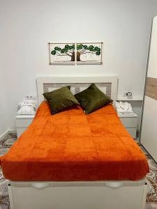 a bedroom with a bed with an orange blanket at Casa Brisa del mar in Puerto de Sagunto