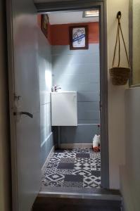 ein Bad mit einem Waschbecken und Fliesenboden in der Unterkunft Le Grenier, Climatisation Terrasse Wi-Fi Netflix 15 mn coeur de ville in Béziers