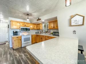 a kitchen with wooden cabinets and a white counter top at Woodchuck Cabin in Duck Creek Village