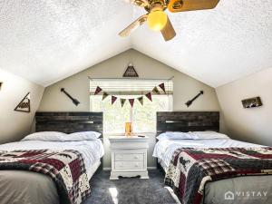 a attic bedroom with two beds and a window at Woodchuck Cabin in Duck Creek Village