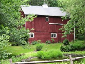 a red barn with a pond in front of it at B&B on seven acres with private bed & bath in Clinton Corners
