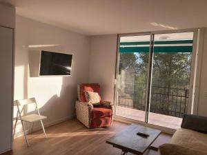 a living room with a couch and a chair and a window at APARTAMENTO 10 MIN SITGES in Puigmoltó