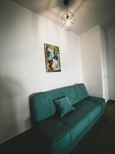 un sofá verde en una habitación con una foto en la pared en Luxury Apartment in the City Center & Free Parking, en Volos
