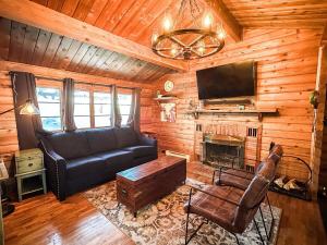 Cabaña con sala de estar con sofá y TV. en Village Vibes Deck And Bbq en Duck Creek Village