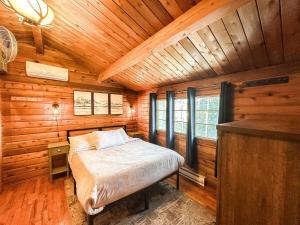 1 dormitorio con 1 cama en una cabaña de madera en Village Vibes Deck And Bbq en Duck Creek Village