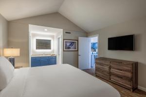 um quarto com uma cama grande e uma televisão de ecrã plano em Raintree's Park Plaza Park City em Park City