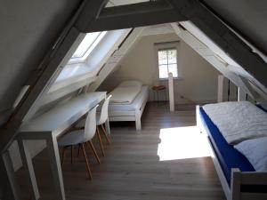 een slaapkamer op zolder met een bed en een bureau bij strandhuis De Bakkeete A in Kamperland