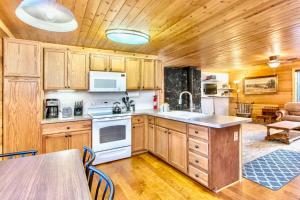 una cocina con armarios de madera y una mesa con sillas. en Lovely Log Cabin With Fire Pit! en Duck Creek Village