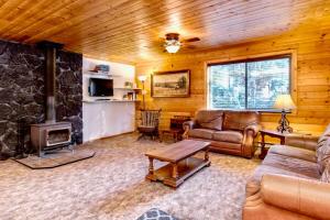 sala de estar con sofá y chimenea en Lovely Log Cabin With Fire Pit! en Duck Creek Village