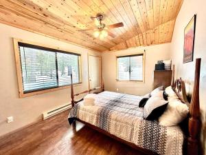 a bedroom with a bed and a ceiling fan at Lovely Log Cabin With Fire Pit! in Duck Creek Village
