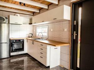 a kitchen with white cabinets and a sink and a stove at Domki Anchor in Lubiatowo