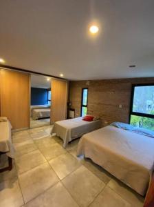 um quarto com 2 camas e uma grande janela em Casa en Country “El Pinar” em Santa Fé