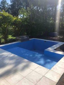 uma piscina azul sentada em cima de um pátio em Casa en Country “El Pinar” em Santa Fé