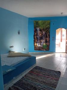 a bedroom with blue walls and a bed with a rug at Palm Valley camp in Nuweiba‘ el Muzeinah