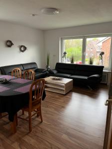 a living room with a black couch and a table at Apartment Geronimo in Werne an der Lippe
