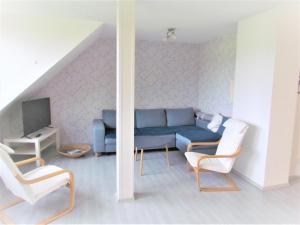 sala de estar con sofá azul y 2 sillas en Ferienwohnung am Radweg en Ruprechtsbruck
