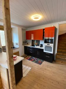 a kitchen with orange cabinets and a stove top oven at Helles, gemütliches Haus mit Moselblick in Müden