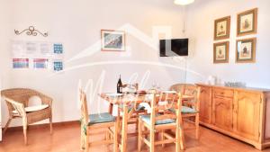 a dining room with a table and chairs at SA TORRETA 3 in Cala Blanca