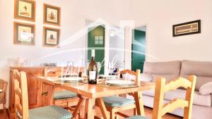 a dining room with a table and chairs and a couch at SA TORRETA 3 in Cala Blanca