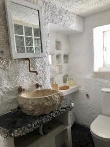 a bathroom with a stone sink and a toilet at Arya's Nest in Mijas