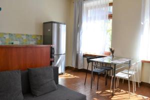 a kitchen with a couch and a table and a refrigerator at Kaletnicza Old Town Apartment in Gdańsk