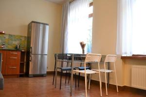 a kitchen with a table with chairs and a refrigerator at Kaletnicza Old Town Apartment in Gdańsk