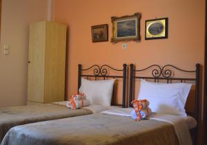 two beds in a hotel room with teddy bears on them at Chrysoula's Guests in Ioannina