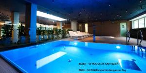 a large blue swimming pool in a building at Penthouse C51 - Golden Tulip in Międzyzdroje
