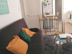 ein Wohnzimmer mit einem Sofa und einem Tisch in der Unterkunft Appartement cosy au calme La Salamandre 