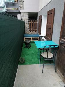 eine kleine Terrasse mit einem blauen Tisch und Stühlen in der Unterkunft Appartement cosy au calme La Salamandre 