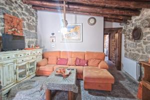 sala de estar con sofá y TV en casa rural La Fragua en Villar de Corneja