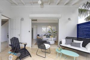 Villa Mango 150 mètres plage à pied في سانت لوسي: غرفة معيشة مع كراسي وأريكة وطاولة