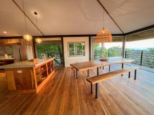 a kitchen with a wooden table and a bench at Ocean View Modern Jungle Vacation Home - Walking Distance to Playa Mal Pais in Mal País