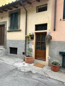 a building with a door and two potted plants in front of it at Casa Maria in Portoferraio