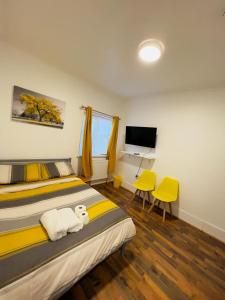 Schlafzimmer mit einem Bett, einem Schreibtisch und einem TV in der Unterkunft WoodGreen house in London