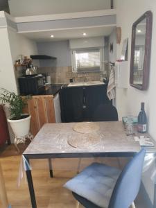 Saint-Privat的住宿－Gîte effet d’art，厨房配有一张桌子和两把蓝色椅子