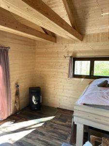 Cabaña de madera con cama y estufa. en Treehouse Velké Losiny en Velké Losiny