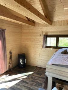 a log cabin with a bed and a stove in it at Treehouse Velké Losiny in Velké Losiny