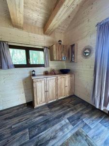 a kitchen in a cabin with wooden floors and windows at Treehouse Velké Losiny in Velké Losiny