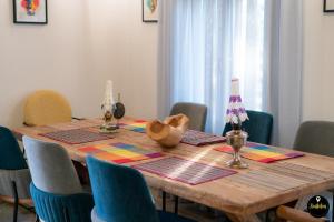 uma mesa de jantar com cadeiras azuis e uma mesa de madeira sidx sidx sidx em Pinolia Rooms em Quios