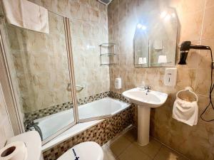 La salle de bains est pourvue de toilettes, d'un lavabo et d'une baignoire. dans l'établissement Hacienda Guadalquivir, à Cordoue