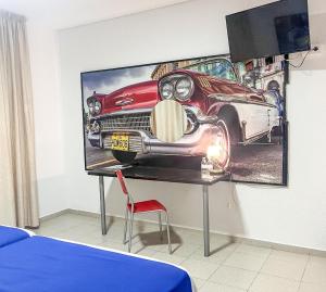 una habitación con una foto de un coche en la pared en Hacienda Guadalquivir, en Córdoba