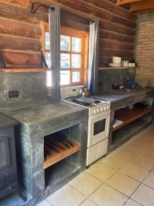 een keuken met een fornuis en een fornuis top oven bij Hermosa Cabaña de Montaña - Parque La Pirámide 