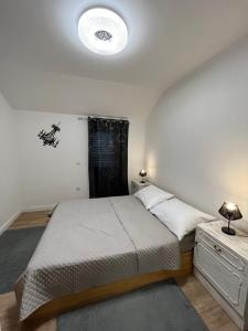 a small bedroom with a bed and a night stand at Kuća za odmor Antonini in Kaštela