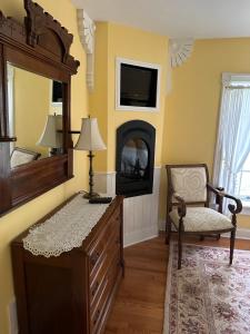 a bedroom with a dresser and a mirror and a chair at Maple Shade Bed & Breakfast 