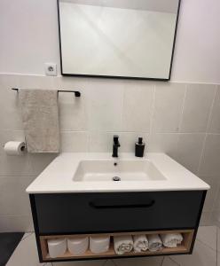 a bathroom with a sink and a mirror and towels at Kuća za odmor Antonini in Kaštela