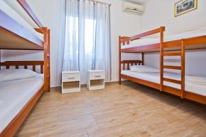 a bedroom with two bunk beds and a window at Luka's Lodge Guesthouse & Hostel in Hvar
